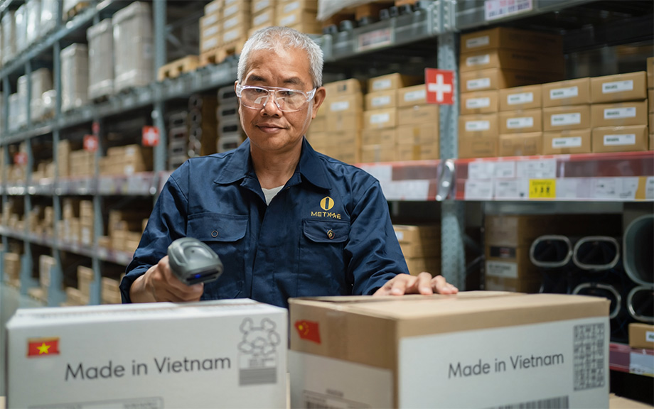 Warehouse worker scanning boxes; boxes marked Made in Vietnam